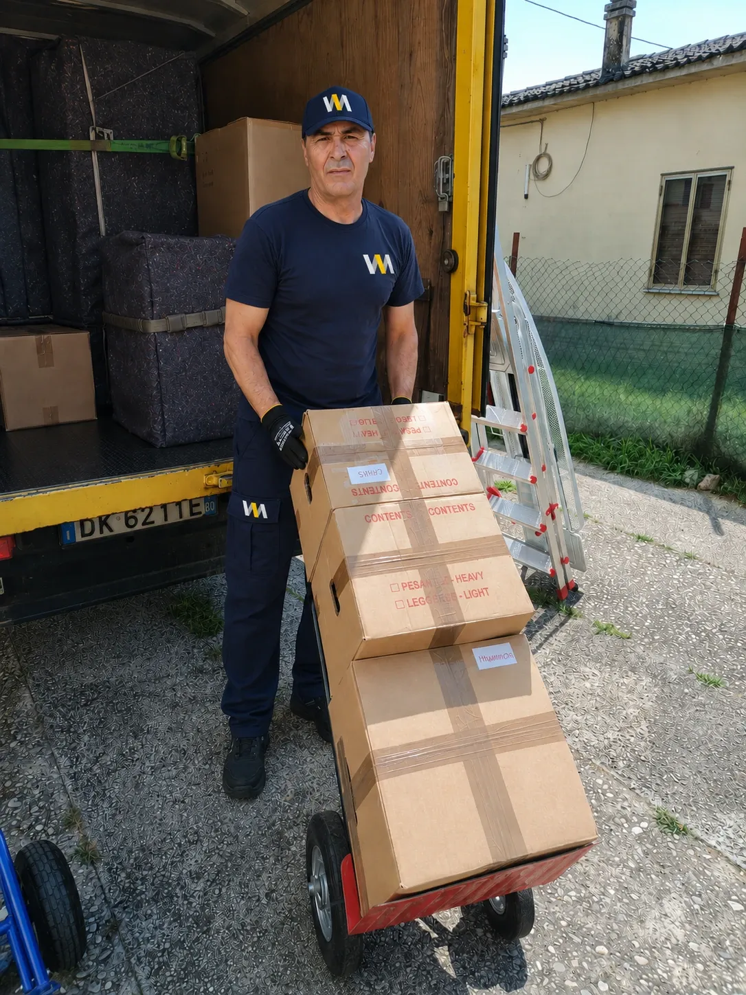 La squadra ENICHOM carica un divano sul camion durante un trasloco.